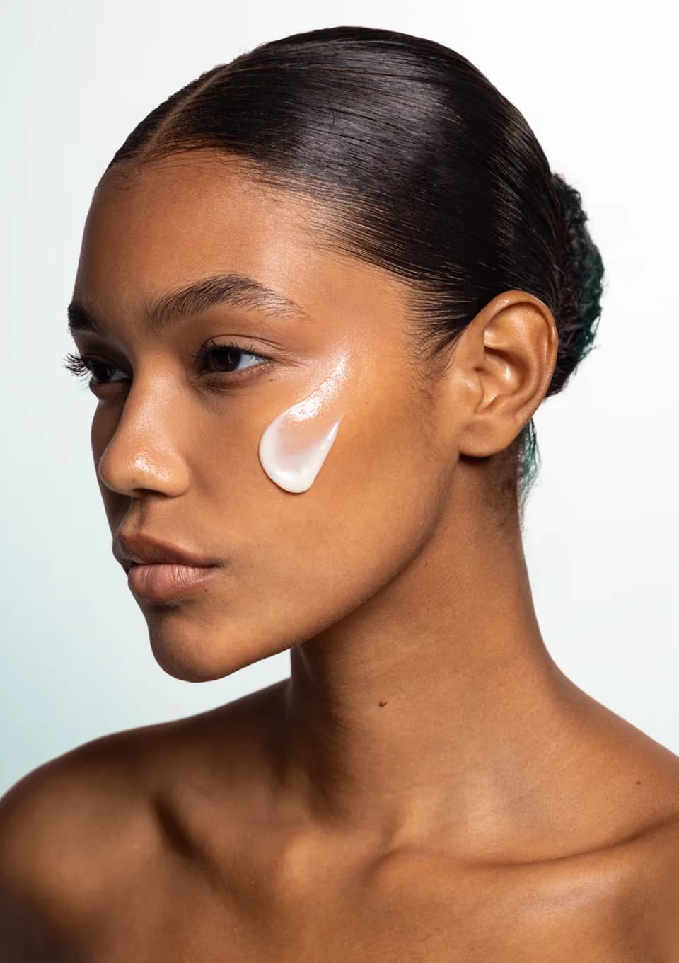 A sweep of the serum smoothed across a model's cheek