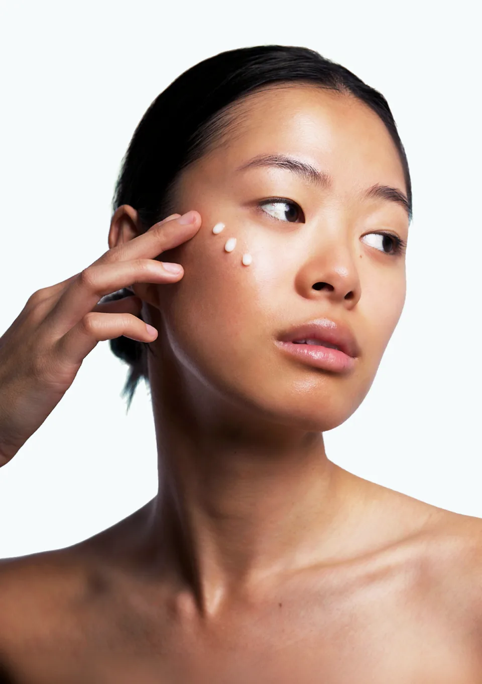 Serum dots being pressed along a model's cheek