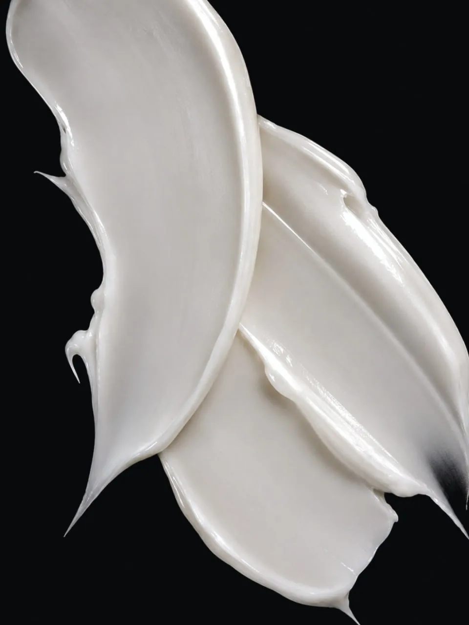 The cream serum texture drawn across a dark surface